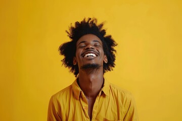 Happy smiling afro man posing on yellow studio background.