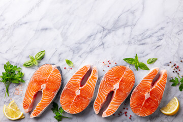 Salmon steaks, fillet with herbs and spices. White marble background. Copy space. Top view.
