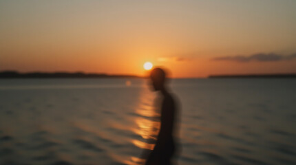 Fototapeta premium Sunset sky and calm sea with a silhouette of a person, creating a sense of solitude and reflection