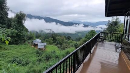 Obraz premium Experience breathtaking green mountains from a balcony in Northern Thailand, where clouds and mist create a serene atmosphere in the hills below