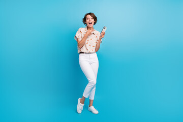Full length portrait of astonished nice person indicate finger smart phone empty space isolated on...