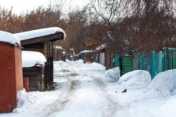 A narrow, snow-covered alley in a quiet neighborhood