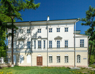 This photograph shows a classic, historic building with a light facade, which appears to be a public or institutional structure
