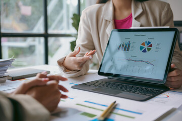 Businesswoman presenting financial data on a tablet to her colleague during a meeting in the office