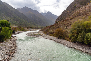 a mountain river in a gorge among mountains and a mountain village