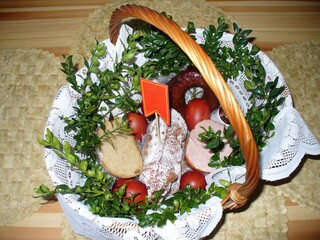 Wicker basket with lamb shaped cake, boiled eggs, cold cuts and bread - Święconka, blessing of Easter baskets, Polish tradition on Holy Saturday with Easter lamb. Topics: holidays, easter breakfast