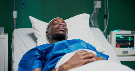 Hospital photo of an African man with an oxygen tube, undergoing treatment for severe respiratory issues.