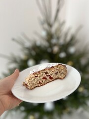 Traditional german christmas cake - cranberry stollen on the christmas tree background.