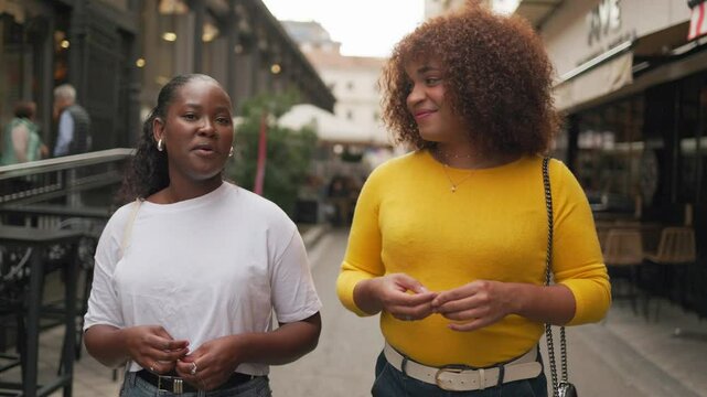 Gen z female friends talking and walking in downtown city. Natural conversation.