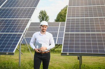 Portrait young technician or manager wearing formal cloths standing with solar panel. renewable...