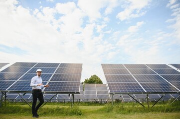 Young architect standing by solar panels