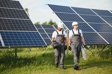 Engineer worker working in solar panels power farm. Two technician working at solar power station