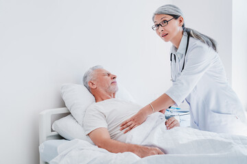 Scared adult female doctor doing check up of hospitalised senior male patient