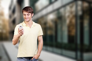 Happy young man hold phone and posing on street background