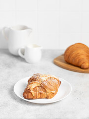 Almond Croissant pastry on a light table. Bright mood style. Perfect for recipe, article, catalogue. 