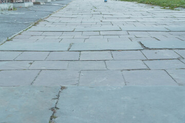 A Serene Perspective of Weathered Paving Stones Along a Sidewalk