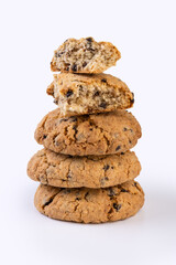 fresh oatmeal cookies with chocolate pieces whole and slices lie on top of each other in a vertical stack in five levels isolated on a white background. side view close-up