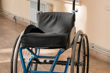 Fototapeta premium A Quiet Moment: An Abandoned Wheelchair in Sunlit Corridor