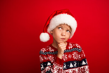 Photo portrait of cute little boy look skeptical empty space celebrate new year wear knitted outfit isolated on red color background