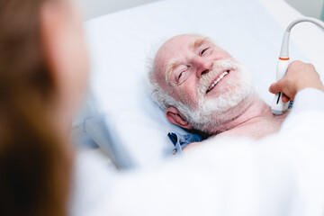 Close up photo of smiling mature male patient being tested with ultrasound scanner