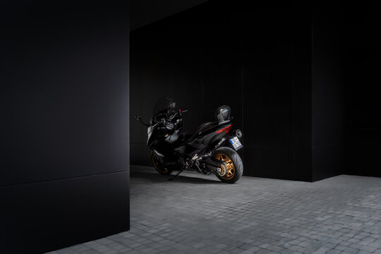 Rear view of Yamaha TMAX Tech 560cc MAX scooter in a sleek, modern black garage setting. The black and gold color scheme highlights its sporty and premium design - 05.06.2024 Subotica, Serbia
