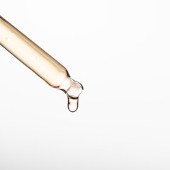 A drop of cosmetic oil falls from the pipette. Skin care cosmetics design package. Retinol or vitamin C serum for damaged skin.