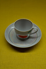 A cup in a saucer on a yellow background, top view. A coffee mug. Espresso Mug