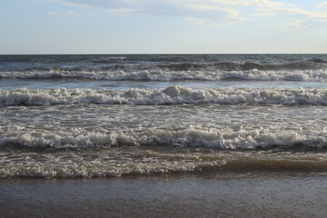 Sea view from the shore. Horizon on the sea. Balearic Sea, Salou, Spain. View of the waves on the sea with small waves from a low angle. Landscape