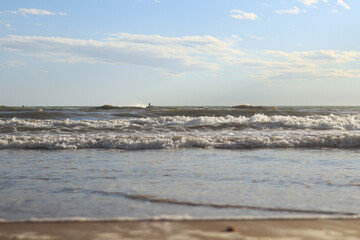 Sea view from the shore. Horizon on the sea. Balearic Sea, Salou, Spain. View of the waves on the sea with small waves from a low angle. Landscape
