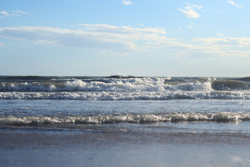 Sea view from the shore. Horizon on the sea. Balearic Sea, Salou, Spain. View of the waves on the sea with small waves from a low angle. Landscape