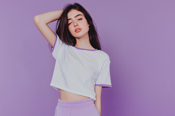 Fototapeta premium Person in white t-shirt with purple edges and purple sweatpants, purple studio background, half-body portrait