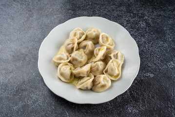 A plate of dumplings sits on a dark table