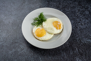 Two eggs with a yellow yolk on a white plate
