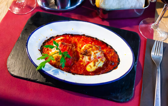 Gratin red bell peppers with filling of codfish under bechamel sauce and cheese