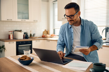Happy freelance worker using laptop at home.
