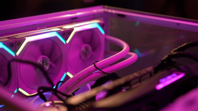 Modern water cooling system keeping temperature of powerful gaming computer low with help of its fans and radiator. Cyberspace blue gaming computer case with fans, water cooling and neon lights.