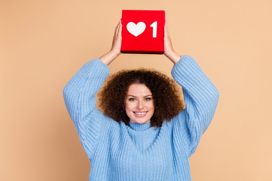 Photo portrait of young funky blogger girl advertising her popular social media holding red like button isolated on beige color background
