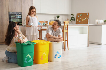Family with recycle trash bins in kitchen