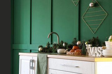 White kitchen counter with Christmas decor near green wall