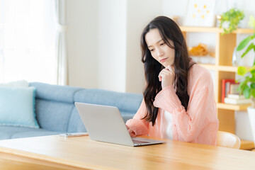 自宅でノートパソコンを操作する女性