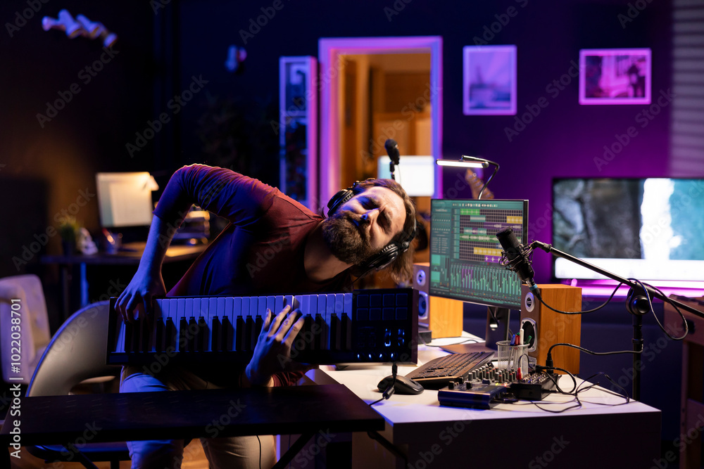 Poster energetic songwriter playing music on electronic keyboard synthesizer and having fun with stereo equ