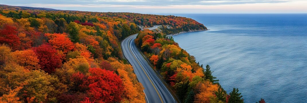 Aerial view of the state highway in Michigan's beautiful Great Lakes region during autumn, with vibrant fall foliage along the road