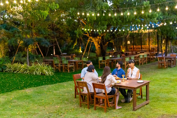 Group of Happy Asian millennial generation people friends enjoy and fun celebration reunion meeting outdoor dinner party with food and drink together in the garden at restaurant on holiday vacation.