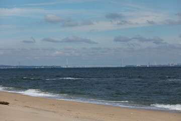 A view of the Verrazzano-Narrows Bridge from Sandy Hook, New Jersey. The Romer Shoal Lighthouse is seen to the left of the bridge.