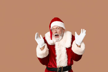 Shocked Santa Claus in glasses on brown background