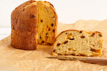 Cut Panettone on parchment on white background