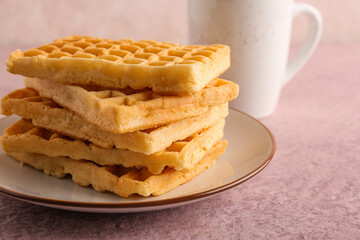 Plate with delicious Belgian waffles on pink background