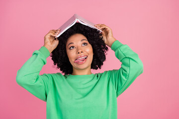 Photo of smart lady with curly black hairstyle wear green sweatshirt holding materials to prepare for exam thinking isolated on pink color background