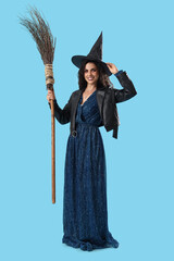 Young witch with broom on blue background