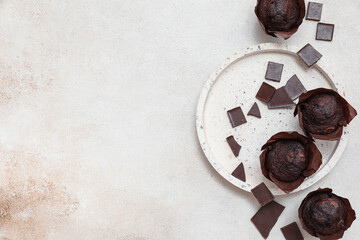 Plate with tasty chocolate muffins on white background